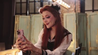 Çekici anime makyajlı sevimli ve güzel genç bir kadın selfie çekiyor. Orta çekim