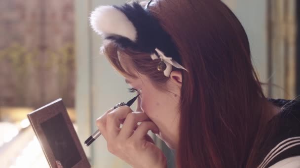 Χαριτωμένη Νεαρή Γυναίκα Ζωγραφίζει Φτερωτό Eyeliner Κοιτάζοντας Στον Καθρέφτη Στην — Αρχείο Βίντεο