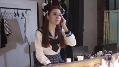 Yüzünün üzerinde pamuk bir bezle yanından geçen sevimli genç bir bayan Cosplayer. Orta çekim