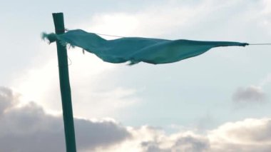 Mavi kumaş fırtınadan önce şiddetli rüzgarda dalgalanır. Orta çekim