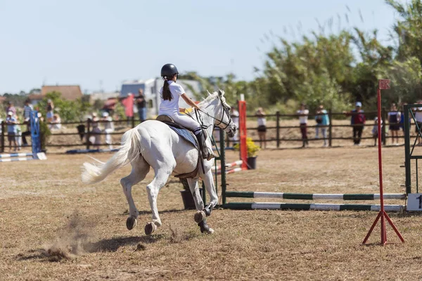 乗馬スポーツ 牧場で白い馬に乗って均一な女の子 障害物を飛び越える ミッドショット — ストック写真
