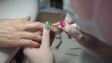 Bir kadın bayan müşterisi için manikür yapıyor. Kapat.