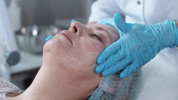 Kosmetologisk Behandling Kosmetolog Masserar Ansiktet Sin Kvinnliga Klient Mittskott — Stockvideo