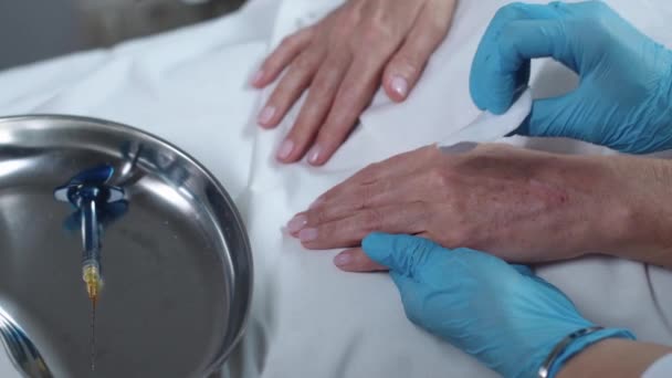 美容外科治疗 美容师擦拭她的女性病人的手部皮肤 — 图库视频影像