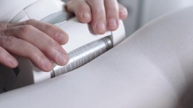 LPG masajı - terapist cihazı beyaz takım elbiseli hastaların vücuduna karşı kullanıyor. Orta çekim