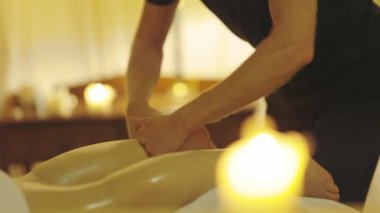 Masaj seansı. Usta, müşterisinin bacaklarına masaj yapıyor. Orta çekim