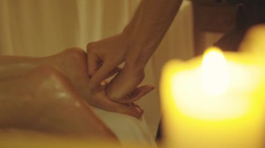 Masaj seansı. Kadın müşterisinin ayağına masaj yapan ustanın elleri. Orta çekim