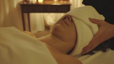 Masaj prosedürü. Kadın müşterinin kafasında havlu var. Orta çekim