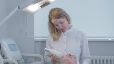 Kozmetik bilimi uzmanı kadın müşterisinin yüzüne masaj yapıyor. Orta çekim