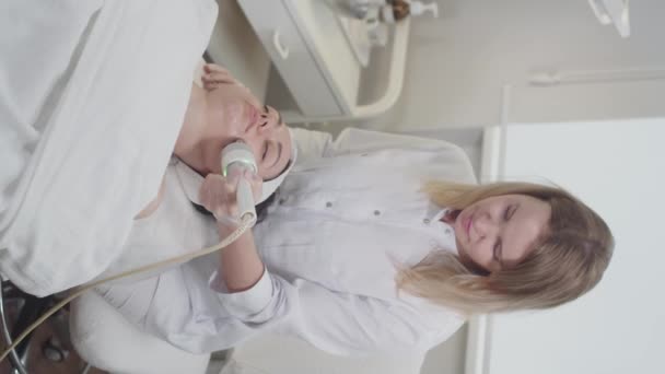 Terapeuten Masserar Ansiktshud Kvinnlig Klient Med Hjälp Kosmetologisk Apparat Hennes — Stockvideo