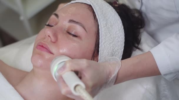 Terapeuta Massageando Pele Facial Uma Jovem Meio Tiro — Vídeo de Stock