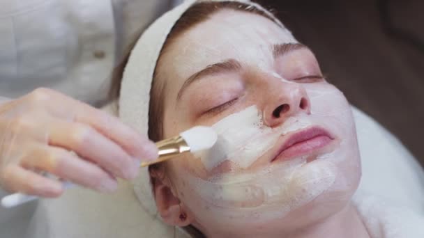 Tratamento Pele Por Cosmetologist Mestre Aplica Uma Máscara Branca Aos — Vídeo de Stock
