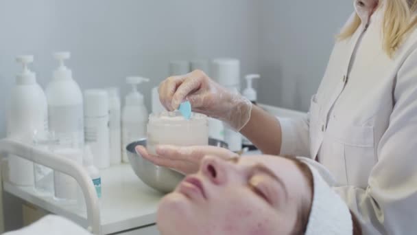 Tratamiento Piel Por Cosmetólogo Maestro Marca Máscara Blanca Espátula Clienta — Vídeo de stock