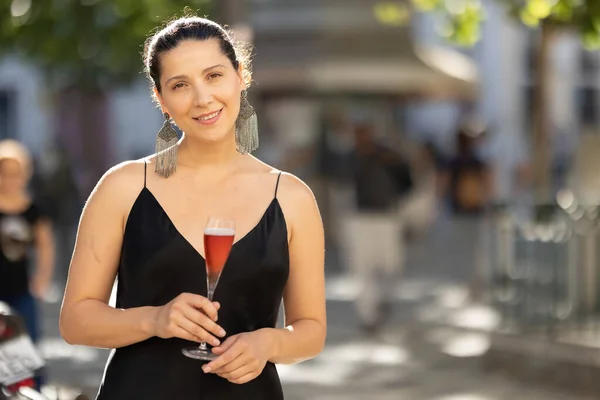 Wanita Tersenyum Pesta Santai Dengan Gaun Elegan Sambil Memegang Minuman Stok Foto Bebas Royalti