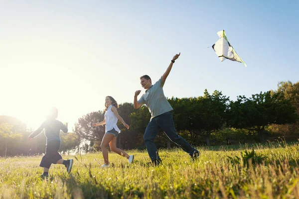 可爱的快乐的家庭在球场上放风筝 — 图库照片