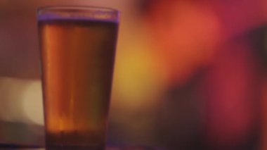 Parlak renkli bir ortamda barda bir bardak light bira. Orta çekim