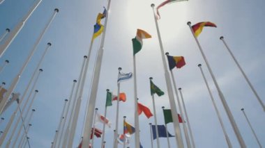 Mavi gökyüzünün arka planında farklı ülkelerin bayrakları. Orta çekim