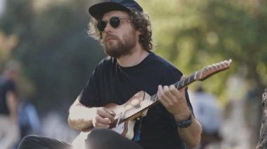 Sokakta gitar çalan bir adam. Orta çekim