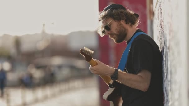 Ein Männlicher Hipster Steht Der Wand Und Spielt Gitarre Mittelschuss — Stockvideo