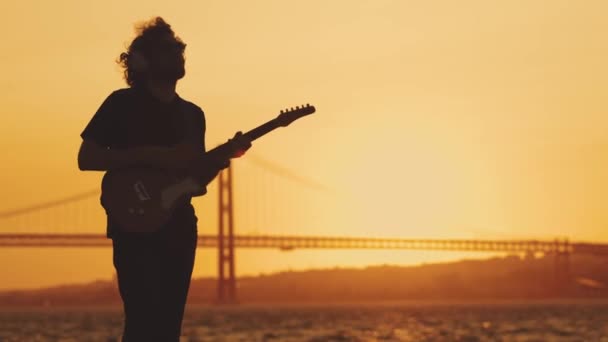 Homem Está Beira Mar Tocar Guitarra Pôr Sol Laranja Meio — Vídeo de Stock