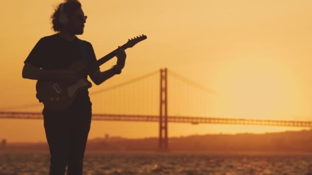 Homem Hipster Fica Beira Mar Toca Guitarra Pôr Sol Laranja — Vídeo de Stock