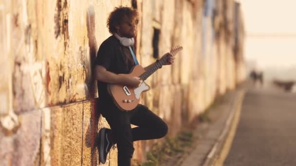Ένας Άντρας Στέκεται Δίπλα Στον Τοίχο Και Παίζει Κιθάρα Στο — Αρχείο Βίντεο