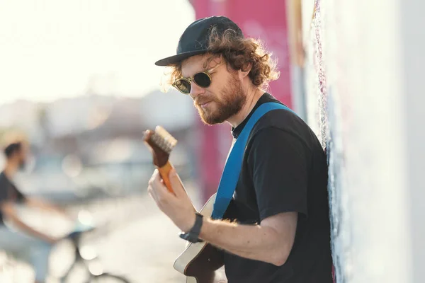 Gülümseyen Hippi Adam Duvarda Dikilip Gitar Çalıyor Orta Çekim — Stok fotoğraf