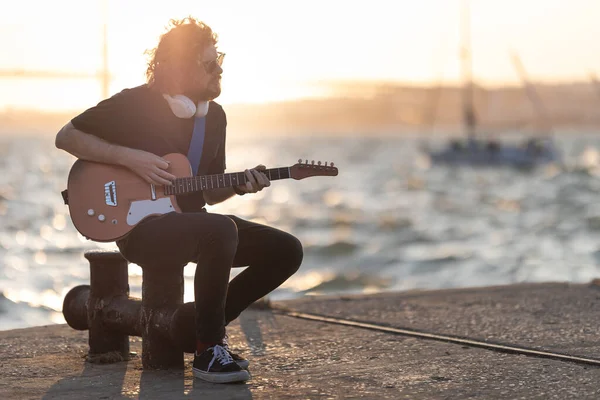 Чоловік Сидить Набережній Грає Гітарі Початку Заходу Сонця Середній Постріл — стокове фото