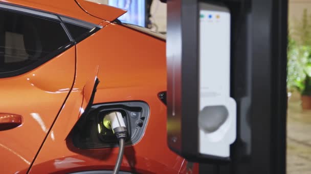 Πορτοκαλί Electro Αυτοκίνητο Χρέωση Στο Σταθμό Φόρτισης Μεσαίο Πλάνο — Αρχείο Βίντεο