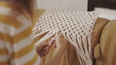 Bir kadın evde makrome dokuyor. Orta çekim