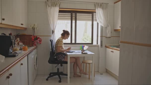 Взрослая Женщина Завтракает Кухонным Столом Смотрит Свой Ноутбук Средний Выстрел — стоковое видео