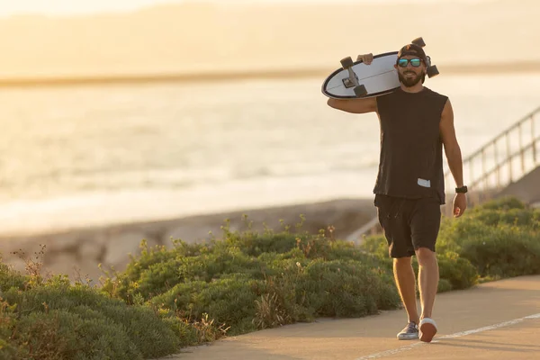 Чоловік Йде Дорозі Біля Пляжу Тримає Скейтборд Середній Постріл — стокове фото