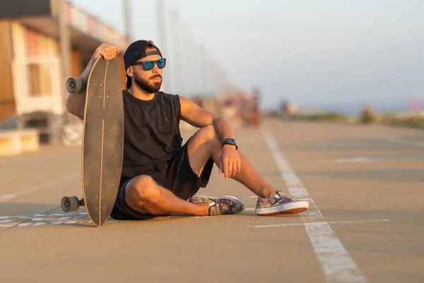 Tipo Fixe Sentado Numa Estrada Com Skate Meio Tiro — Fotografia de Stock