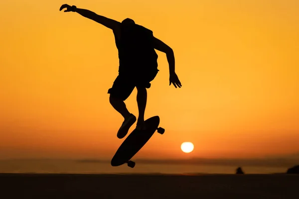 Silhuett Man Som Utför Skateboard Trick Vid Ljus Orange Solnedgång — Stockfoto