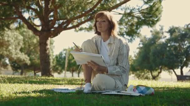Una Mujer Adulta Inspirada Sentada Parque Verde Pintando Cuaderno Bocetos — Vídeos de Stock