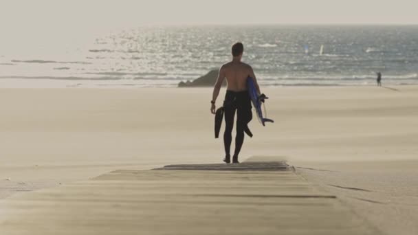Surfista Caminha Longo Caminho Praia Segurando Uma Prancha Surf Meio — Vídeo de Stock