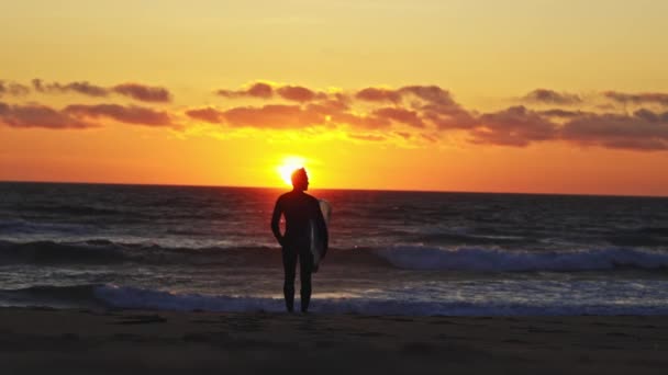Silhouette Surfista Uomo Piedi Verso Oceano Tramonto Arancione Mid Shot — Video Stock