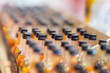 Siyah kapaklı şurup şişeleri sıraya dizildi. Orta çekim