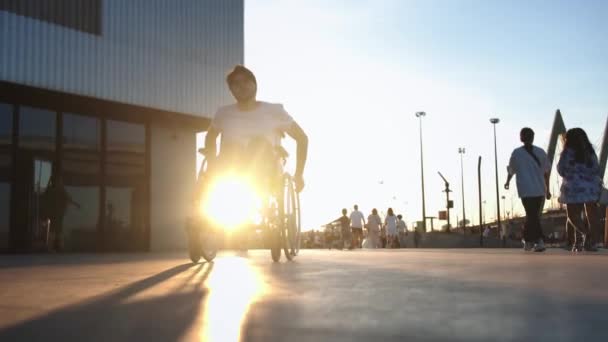 Ein Mann Rollstuhl Bei Sonnenuntergang Auf Der Überfüllten Straße Mittelschuss — Stockvideo