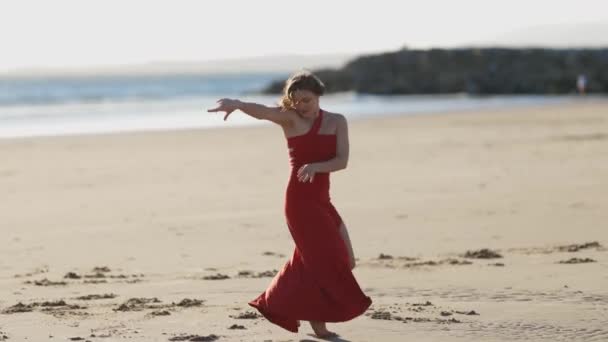 Egy Vörös Ruhás Táncol Parton Középső Felvétel — Stock videók