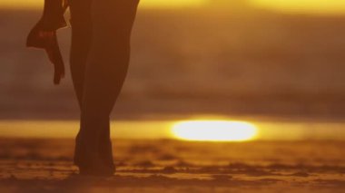 Gün batımında dans eden zarif genç bir kadının çıplak ayakları. Orta çekim
