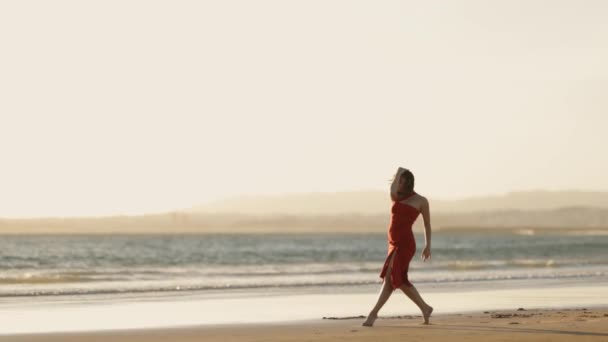 美丽的年轻女子穿着红衣 日落时分在岸上跳舞 — 图库视频影像