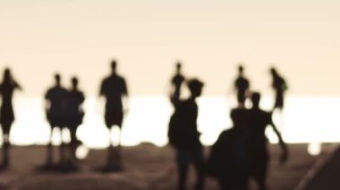 Bulanık siyah siluetler, parlak beyaz ışıkta setin üzerinde yürüyen insanlar. Orta çekim