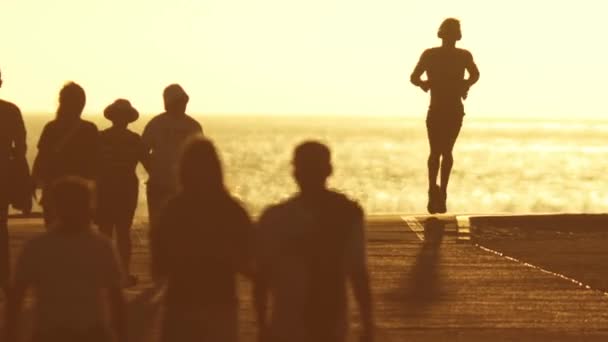 Multidão Jovens Caminhando Beira Mar Pôr Sol Homem Correndo Seus — Vídeo de Stock