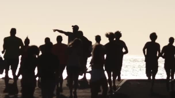 Grupp Idrottsutövare Som Joggar Vid Havet Vid Solnedgången Mittskott — Stockvideo