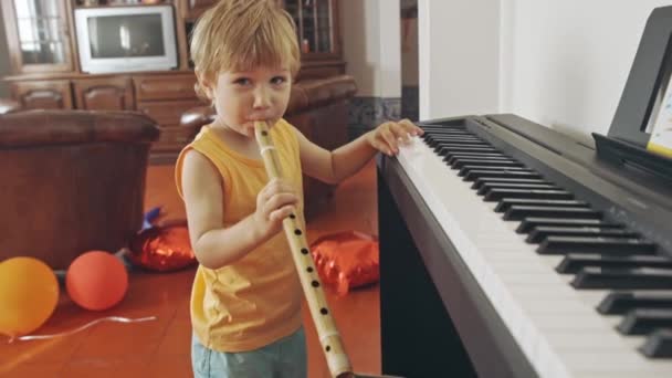 Мальчик Взрывает Флейту Играет Синтезаторе Средний Выстрел — стоковое видео