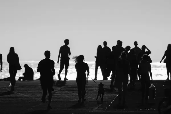 Монохромный Снимок Силуэтов Людей Идущих Холму Моря Средний Выстрел — стоковое фото