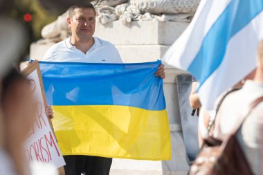 20 Ağustos 2023 Restauradores Meydanı, Lizbon, Portekiz: Savaşa karşı Rus, Beyaz Rusyalı ve Ukraynalı aktivistler tarafından düzenlenen mitingde yetişkin bir adam Ukrayna bayrağını taşıyor. Orta çekim