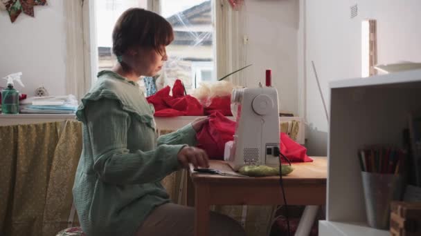 Uma Mulher Costura Uma Peça Roupa Vermelha Uma Máquina Costura — Vídeo de Stock