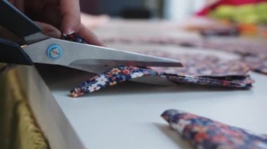 Makas kullanarak kumaşın şablonlarını kesiyor. Orta çekim